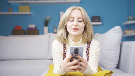 Young-blonde-woman-texting-on-the-phone-while-lying-down.